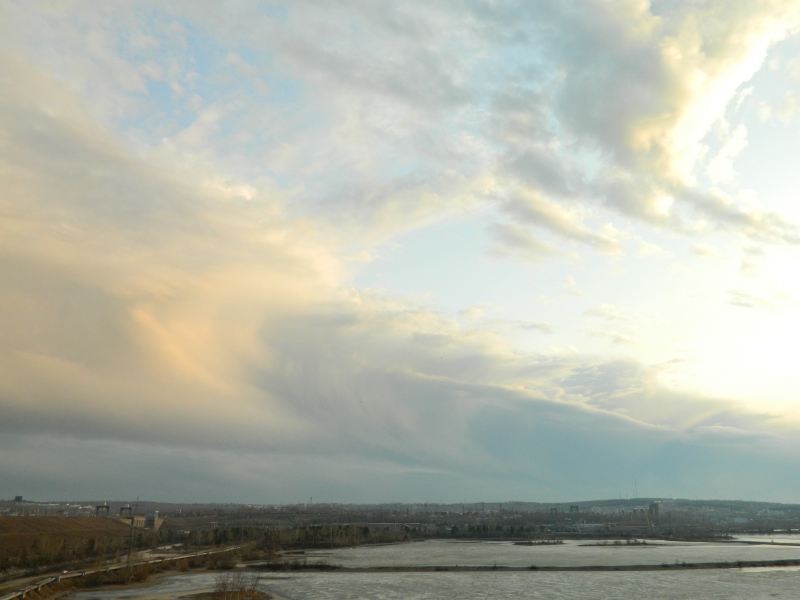 Интересной формы облака над плотиной Иркутской ГЭС по Ангаре.Облачное цунами.