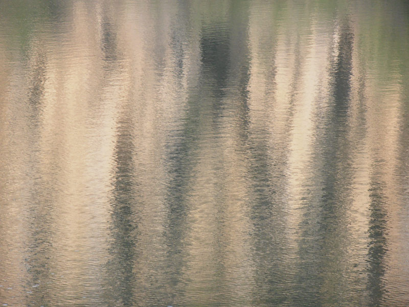 Тяжелые гардины. Отражение в воде озера высокого каменистого берега с небольшим количеством зелени в условиях мельчайшей ряби  и бокового (слева) солнца.