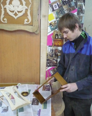 Фигурная панель тонируется морилкой под цвет ореха и покрывается лаком. Устанавливается «стекло» (целлулоидная пленка). Навешивается задняя дверца, устанавливается замок-защелка. Отлакированные детали склеиваются. 