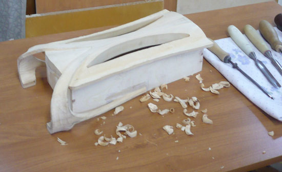 Конструкция наклеивается на корпус шкафа через бумажную прослойку. После выполнения резьбы бумажная прослойка позволяет отделить без разрушения фигурную панель от корпуса.