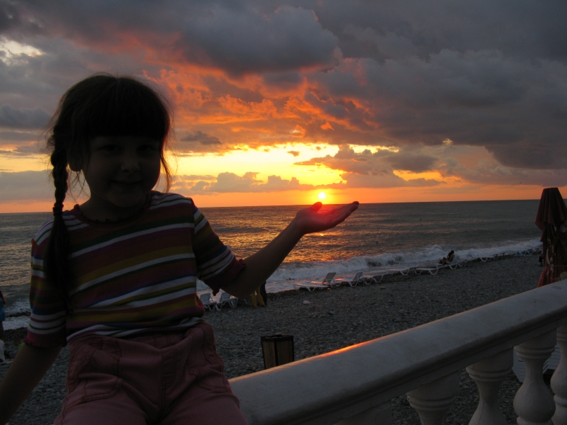 Ребенок ловит последний луч уходящего Солнца.
