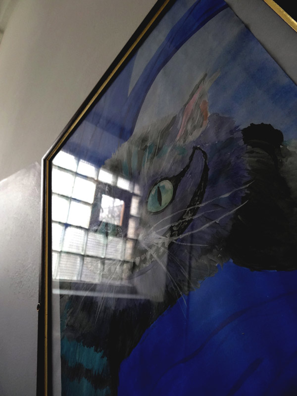 Отражение окна добавило "шарма" улыбающемуся на рисунке коту.